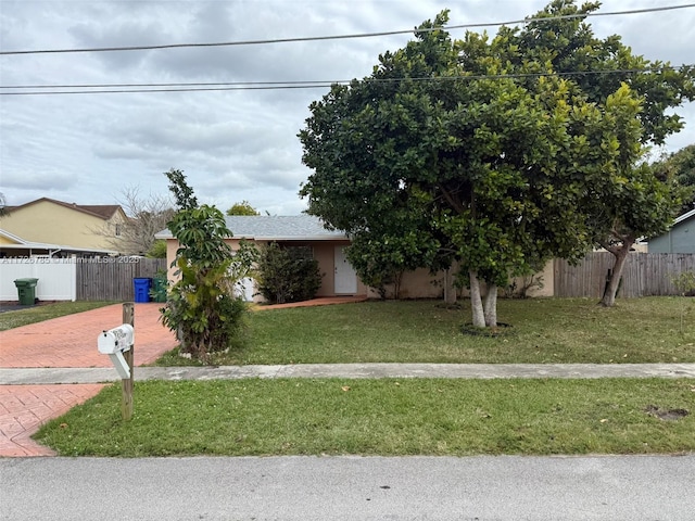 view of property hidden behind natural elements featuring a front lawn