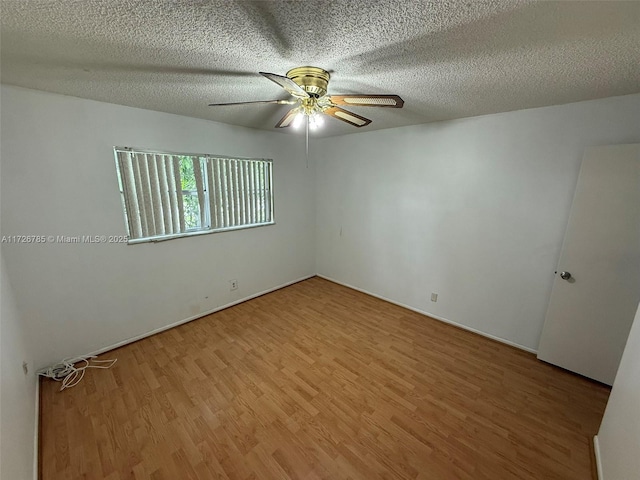 empty room featuring a textured ceiling, ceiling fan, and wood-type flooring