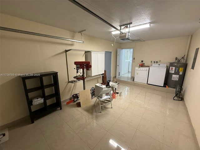 garage featuring washer and dryer, electric water heater, and a garage door opener