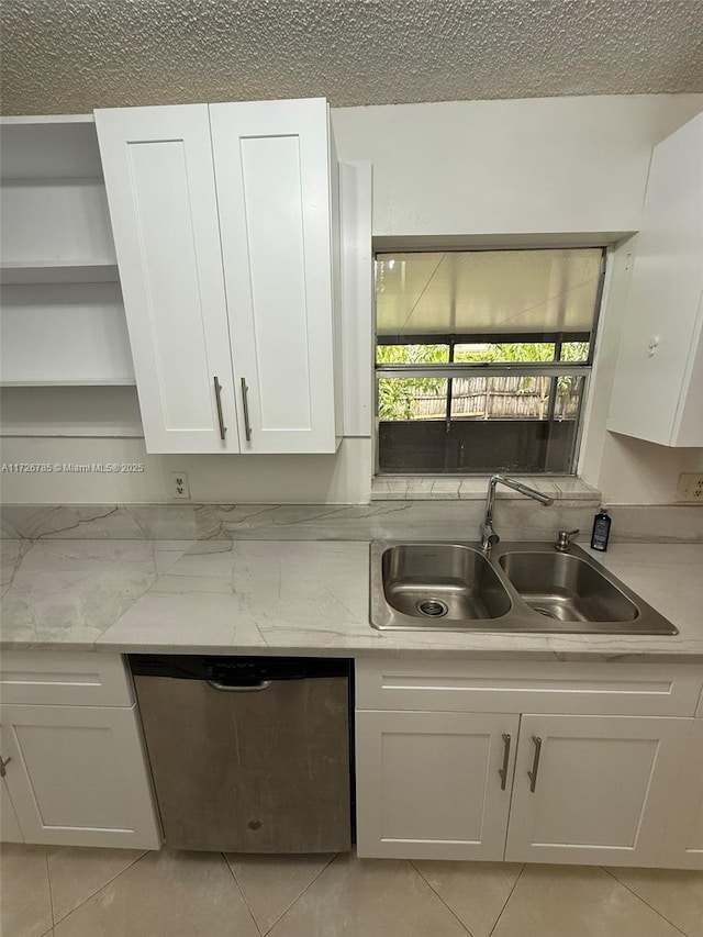 kitchen with dishwasher, light stone countertops, light tile patterned floors, sink, and white cabinetry