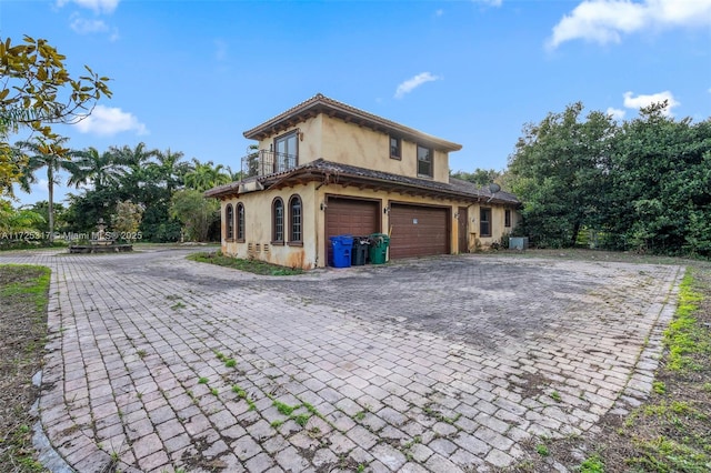 view of side of property featuring central AC unit and a garage