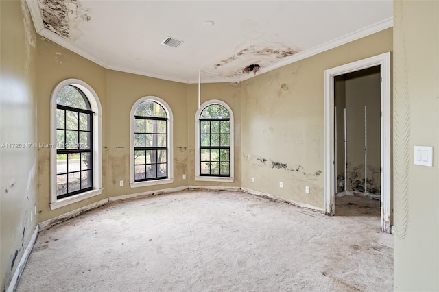 empty room with light colored carpet, crown molding, and plenty of natural light