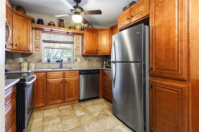 kitchen with light stone counters, stainless steel appliances, tasteful backsplash, and sink