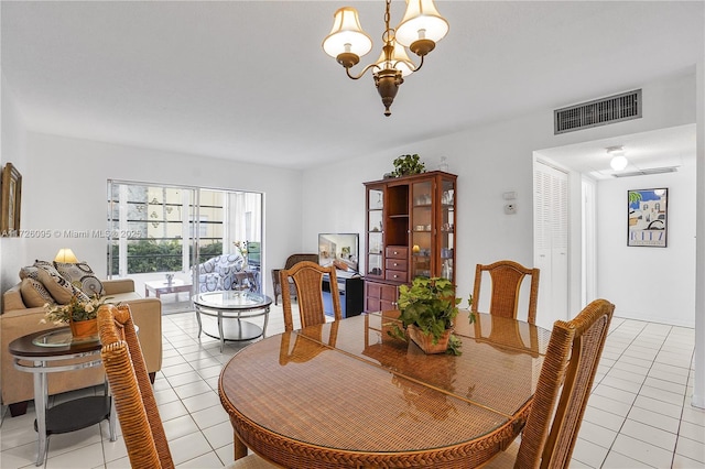 dining space featuring light tile patterned flooring and an inviting chandelier