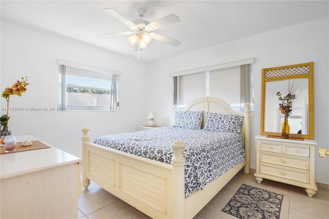 tiled bedroom featuring ceiling fan