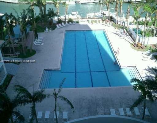 view of pool featuring a patio and a water view