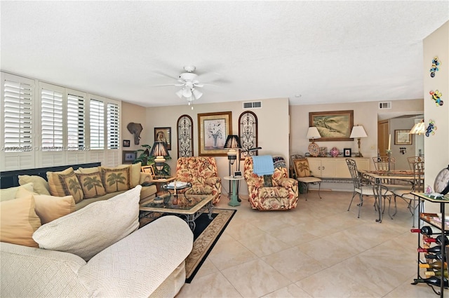 tiled living room featuring a textured ceiling and ceiling fan