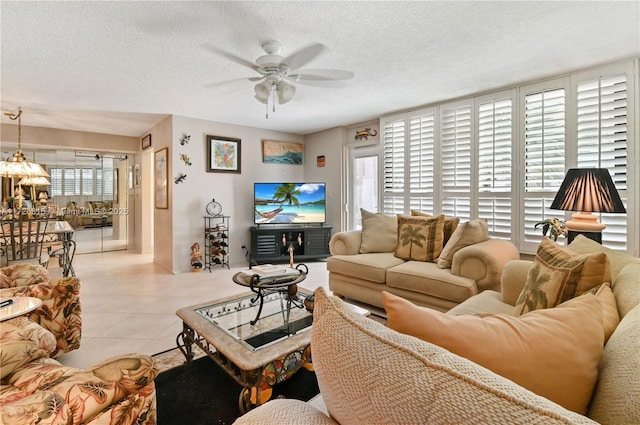 living room with a textured ceiling, ceiling fan, and light tile patterned floors