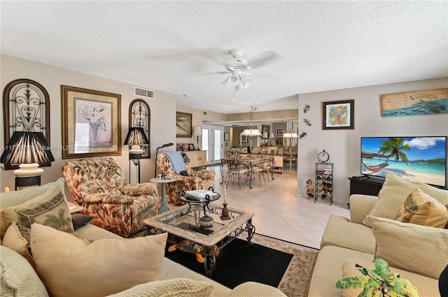 tiled living room featuring a textured ceiling and ceiling fan