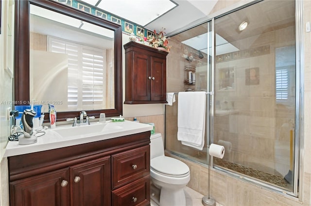 bathroom with walk in shower, vanity, and toilet