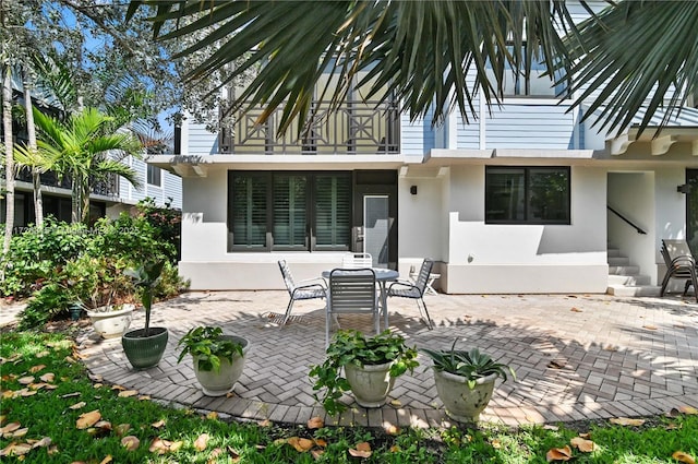 rear view of property featuring a patio area and a balcony