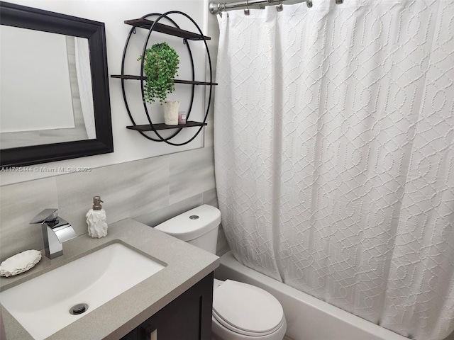 full bathroom featuring toilet, shower / tub combo, tile walls, decorative backsplash, and vanity