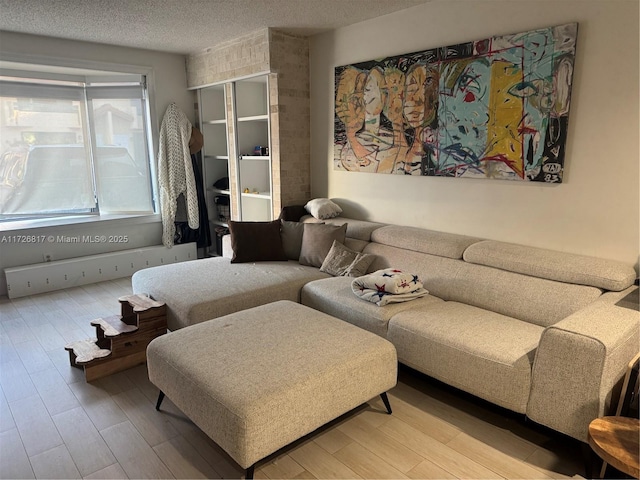 living room with light wood-type flooring and a textured ceiling