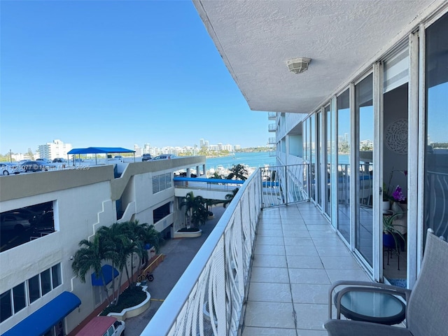 balcony featuring a water view and a city view