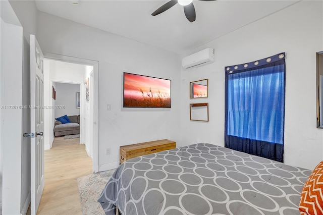 bedroom with ceiling fan, light hardwood / wood-style flooring, and an AC wall unit