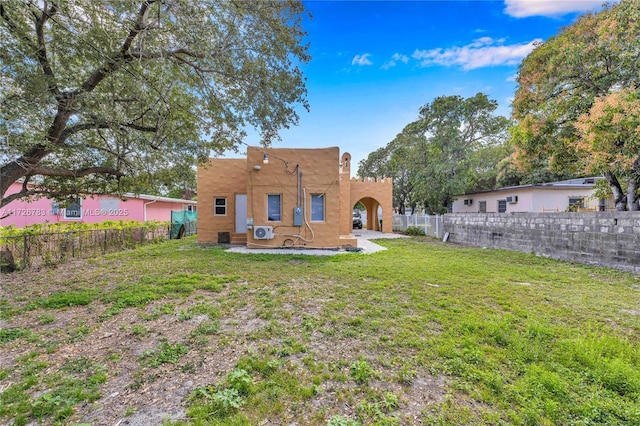 rear view of property featuring a lawn