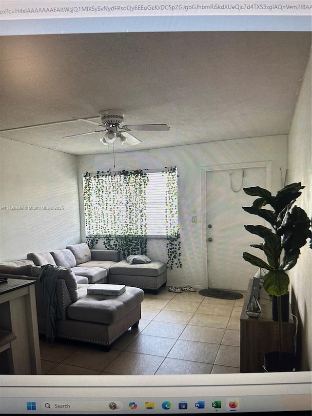 living room with a textured ceiling and ceiling fan