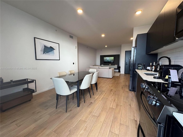 dining area featuring sink and light wood-type flooring