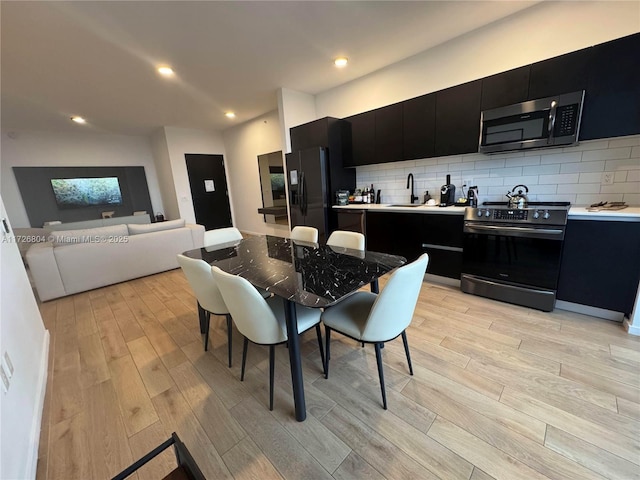 kitchen with stainless steel appliances, sink, and tasteful backsplash