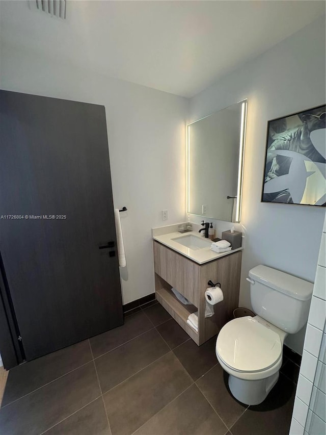 bathroom featuring tile patterned floors, vanity, and toilet