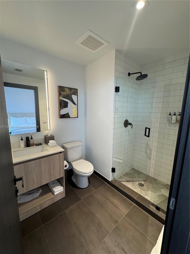 bathroom featuring vanity, tile patterned flooring, toilet, and walk in shower