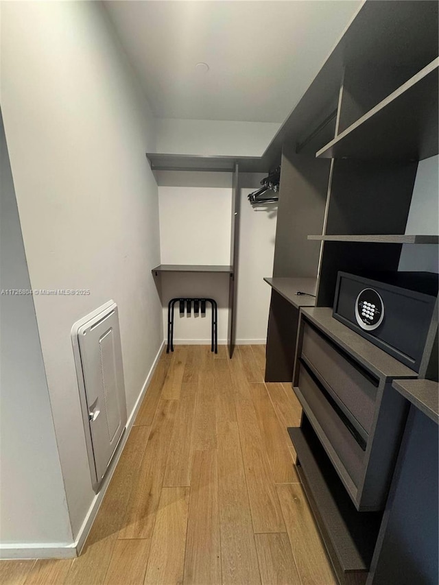 spacious closet featuring heating unit and light hardwood / wood-style floors