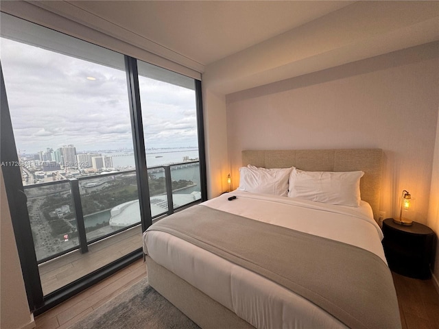 bedroom featuring a wall of windows and hardwood / wood-style floors