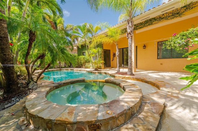 view of swimming pool featuring a patio and an in ground hot tub