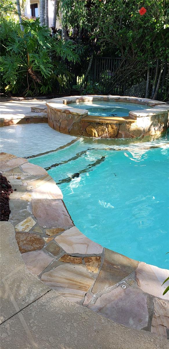 view of swimming pool featuring an in ground hot tub