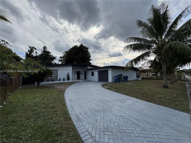 single story home with a front yard and a garage