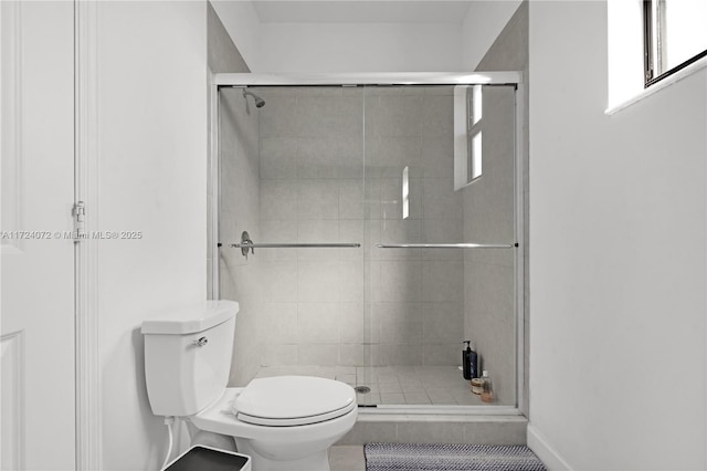 bathroom with tile patterned floors, an enclosed shower, and toilet