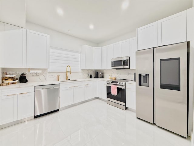 kitchen with appliances with stainless steel finishes, white cabinetry, tasteful backsplash, and sink