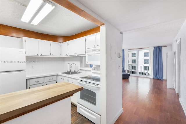 kitchen featuring butcher block countertops, a sink, white cabinetry, and white appliances