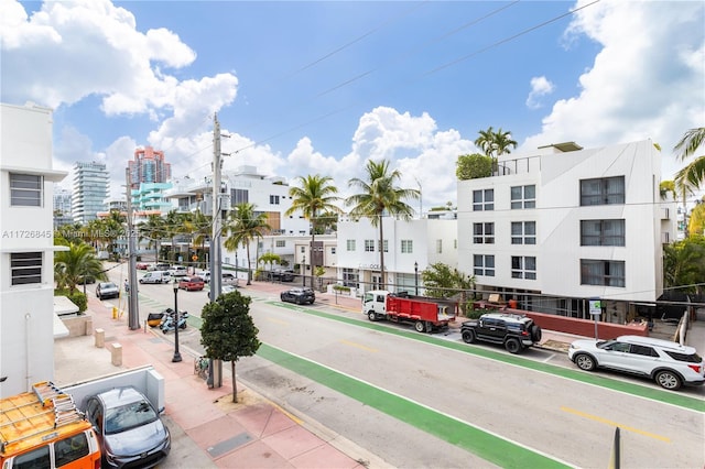 view of street featuring a view of city, sidewalks, street lighting, and curbs