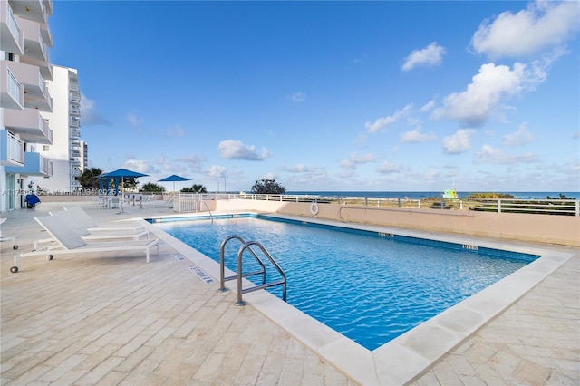 view of swimming pool with a water view and a patio