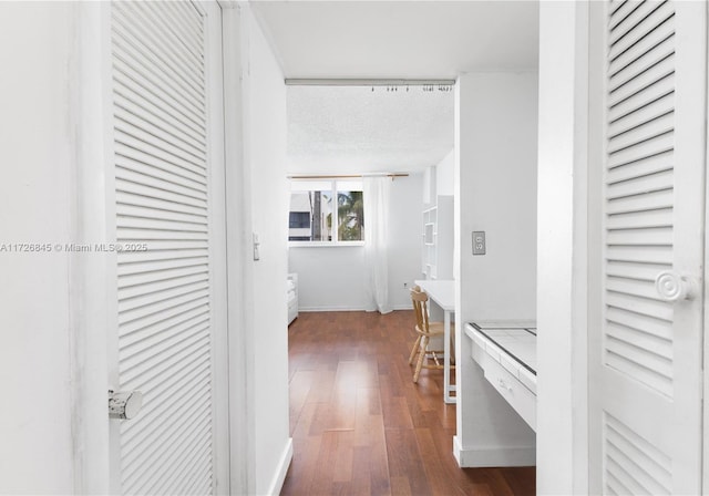 hall featuring a textured ceiling and dark hardwood / wood-style flooring