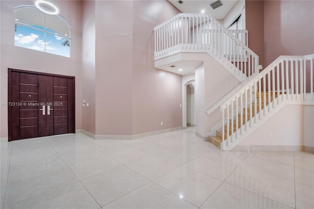 entryway featuring a high ceiling and light tile patterned flooring