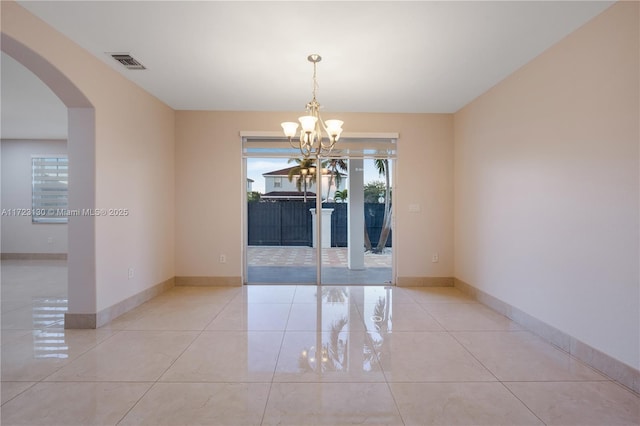 spare room with light tile patterned floors and a notable chandelier