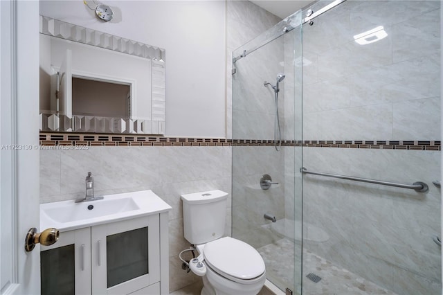 bathroom featuring vanity, tile walls, toilet, and walk in shower