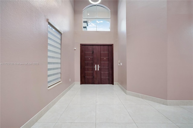 tiled entryway featuring a towering ceiling