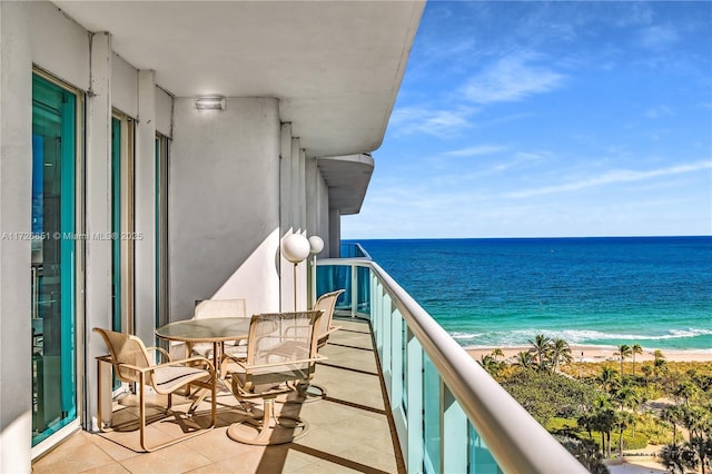 balcony with a water view and a view of the beach