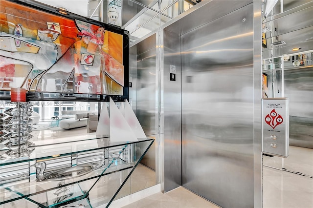 interior space with light tile patterned flooring and elevator