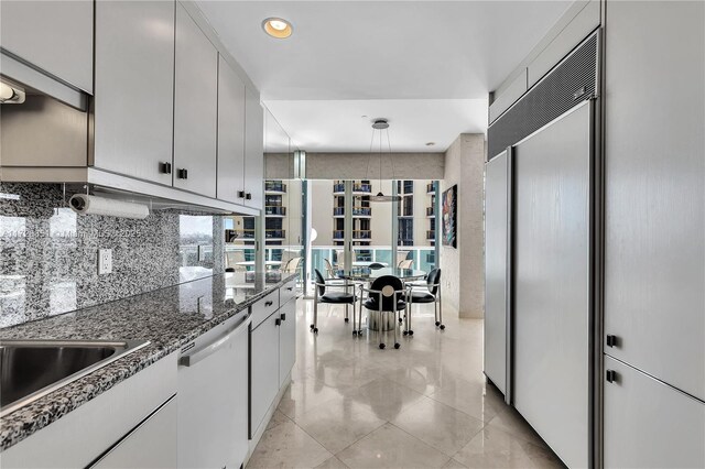 kitchen featuring dishwasher, pendant lighting, white cabinets, and dark stone counters