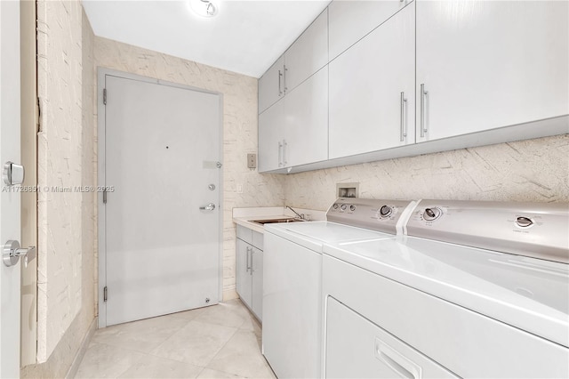 washroom featuring independent washer and dryer, cabinets, light tile patterned flooring, and sink