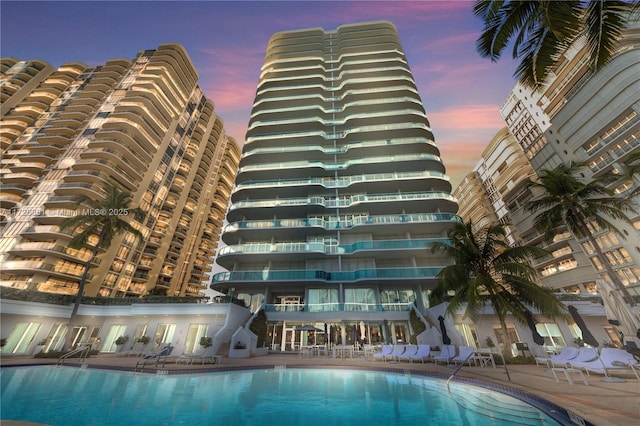 pool at dusk with a patio