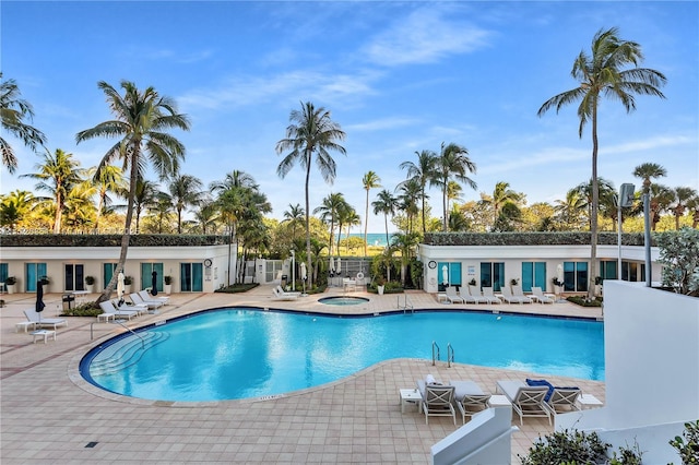 view of swimming pool with a community hot tub and a patio area