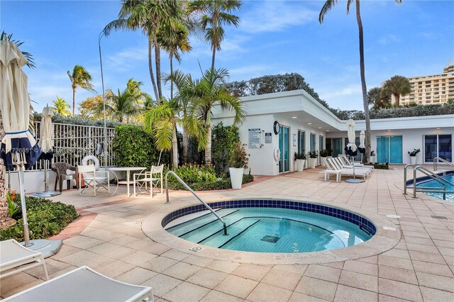 view of swimming pool featuring a patio area and a hot tub