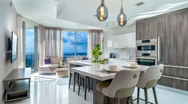 tiled dining room featuring sink and floor to ceiling windows