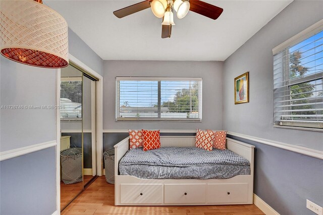 bedroom with ceiling fan, light hardwood / wood-style floors, and a closet