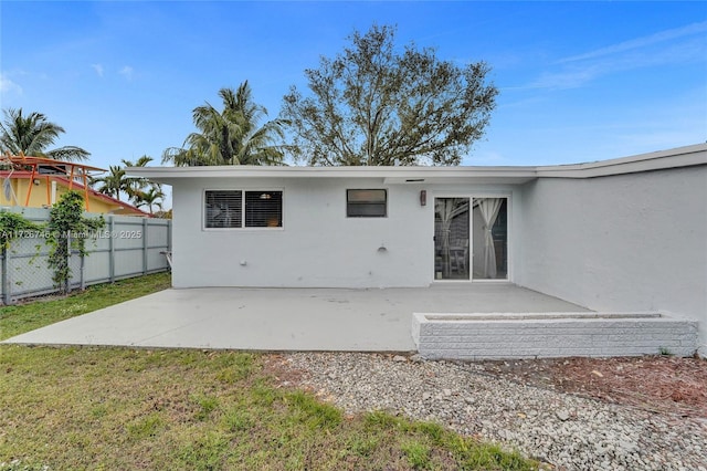 rear view of house featuring a yard and a patio